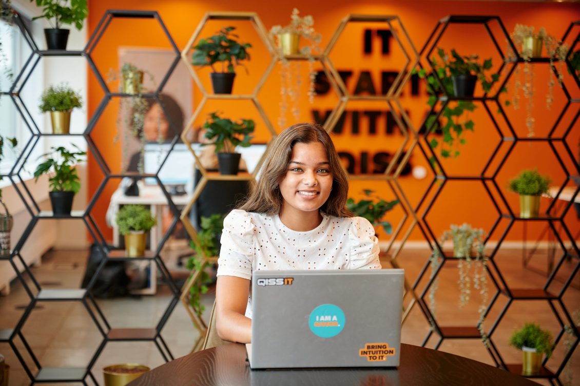 IT Trainee bij QISSI IT kantoor lachend achter haar laptop