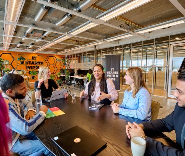 IT Trainees en young IT professionals van QISS IT zitten aan tafel en bespreken een DISC test