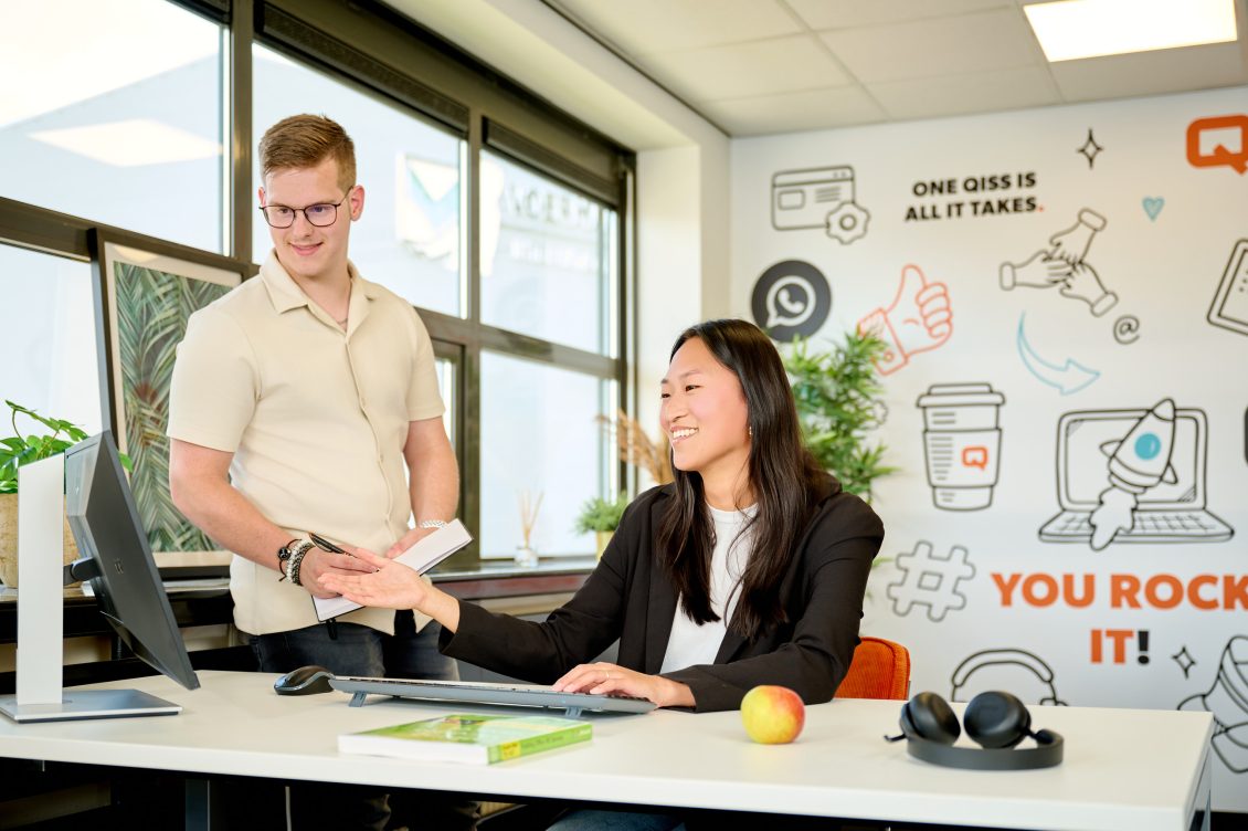 IT professionals van QISS IT zitten en staan achter een bureau