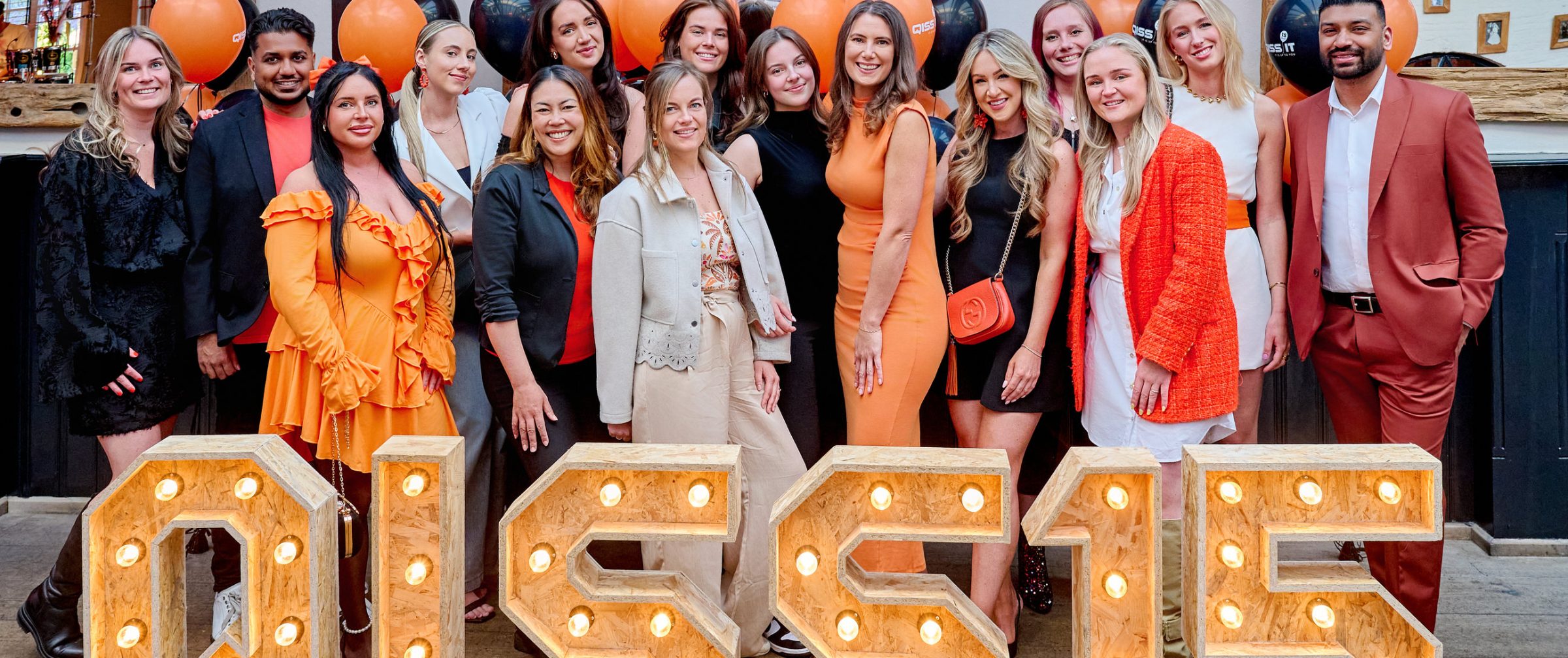 Medewerkers van QISS IT staan achter gouden letters met QISS 15 jaar