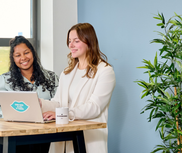 IT professional en recruiter van QISS IT bespreken staand achter hun laptop de NEN certificering