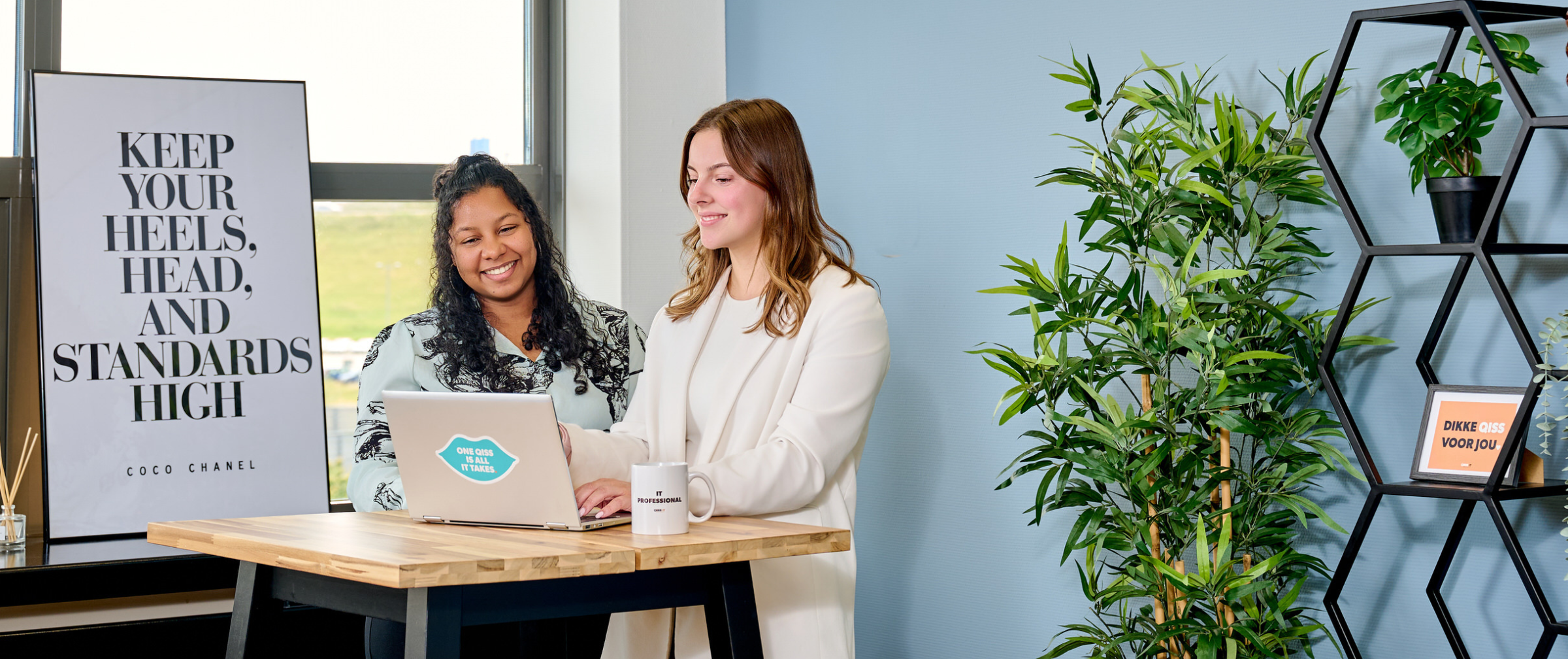 IT professional en recruiter van QISS IT bespreken staand achter hun laptop de NEN certificering