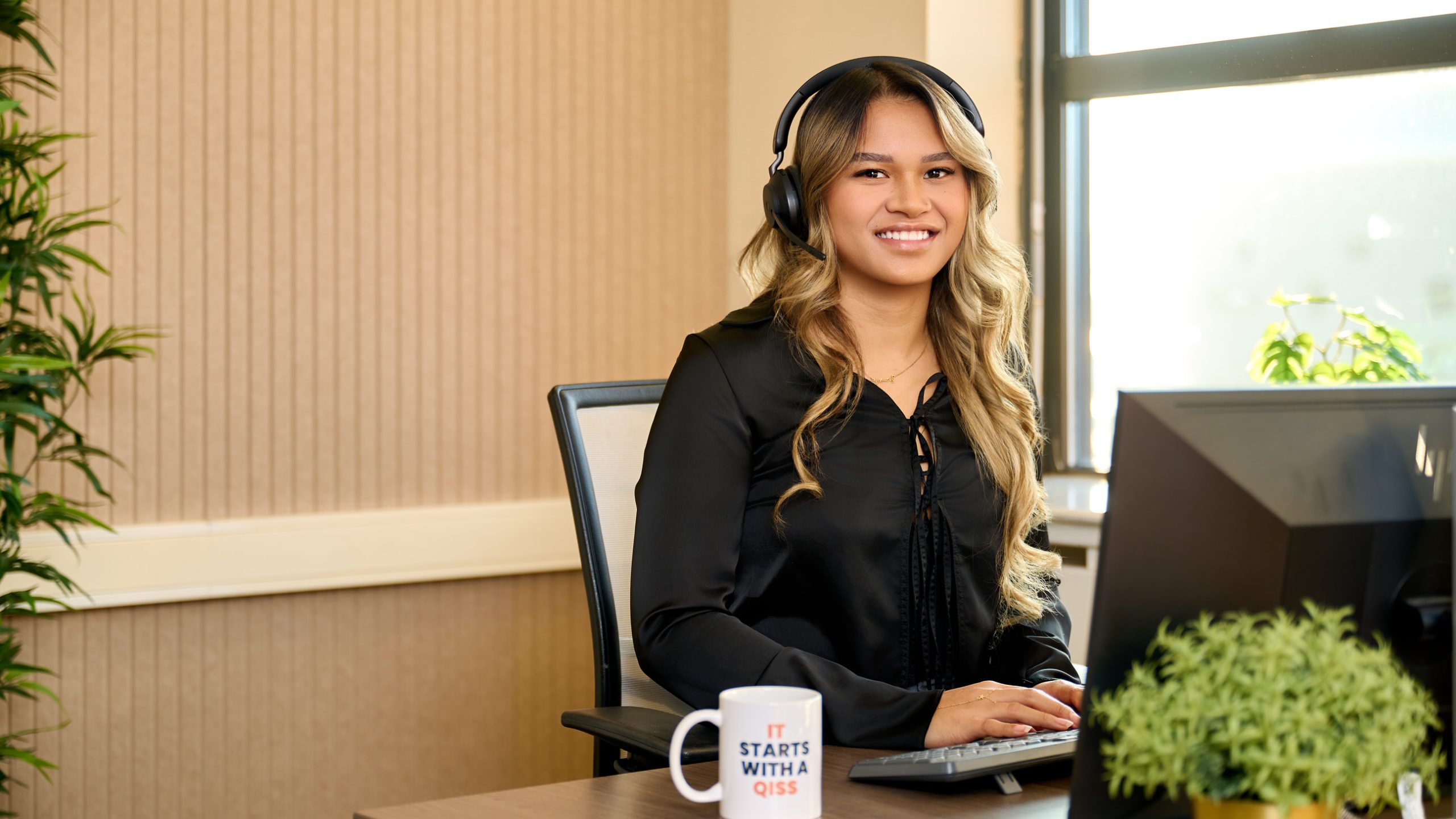 IT-Professional van QISS IT zit achter haar bureau met een headset op